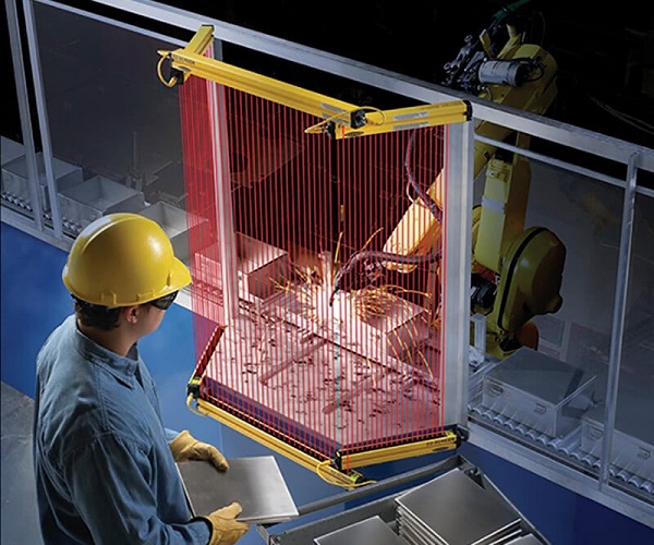 Worker standing near a safety light curtain