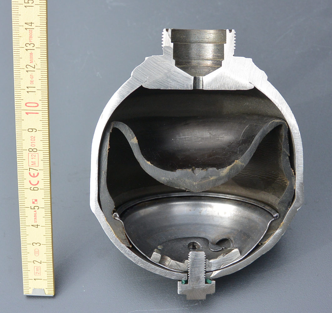 cross section view of fluid accumulator showing fluid entrance / exit valve port at top