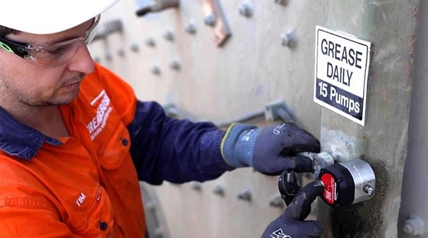 Maintenance worker completing a greasing task