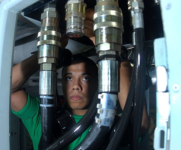 Technician inspecting hydraulic lines
