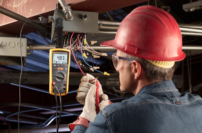 Electrician using a megaohmmeter (megger)