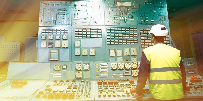 Technician monitoring a display and control panel