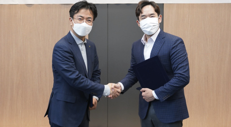 Yoon Dae-gyu (of Hyundai Robotics) and Yoon Seong-ho (of MakinaRocks) shaking on the company partnership