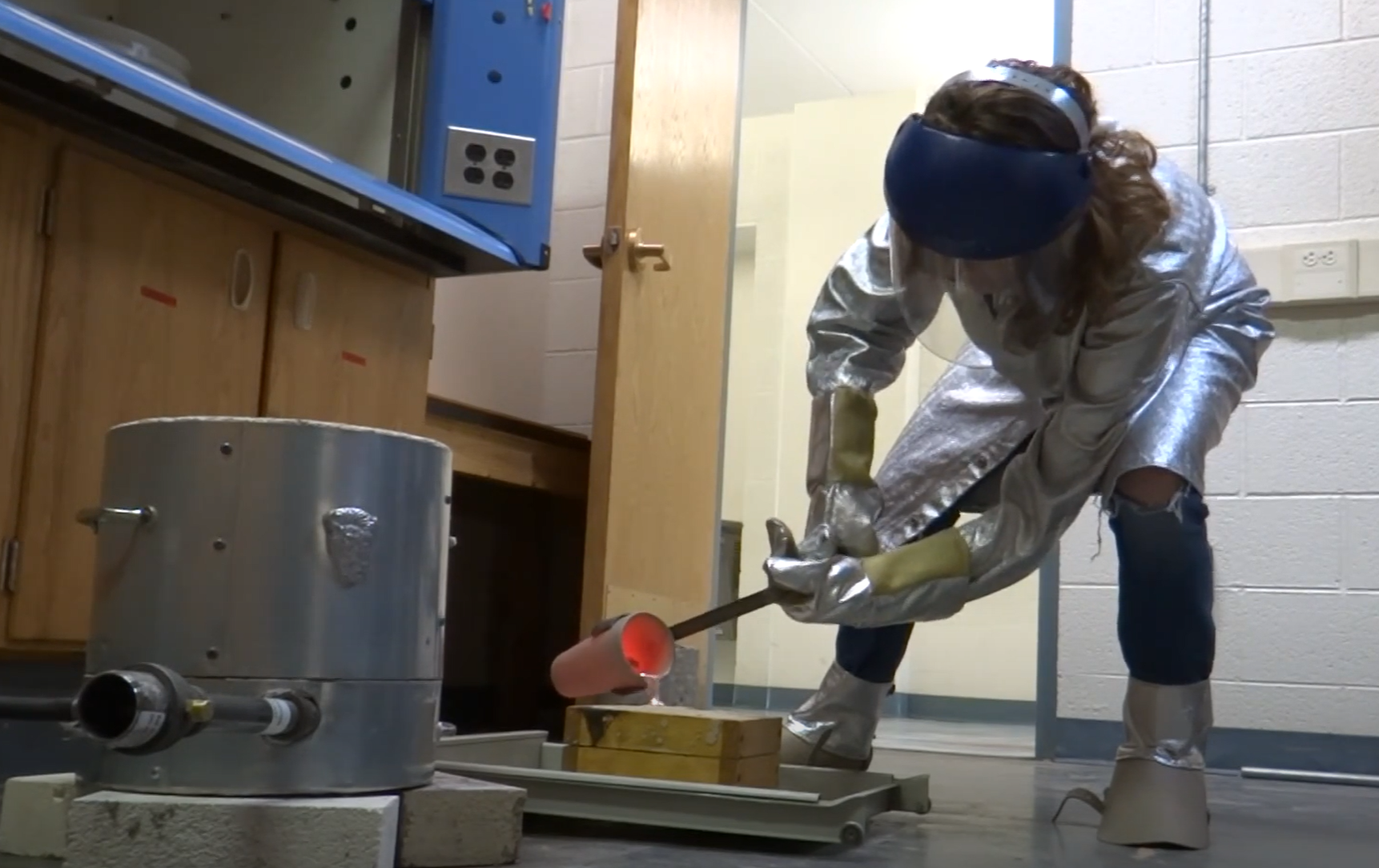 author image of student pouring molten aluminum into a sand mold